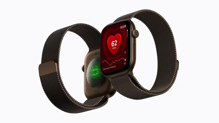 Apple Watch Series 12产品图，两只手表以正反面交错方式展示，并搭配深棕色金属编织表带。前方手表屏幕显示心率监测界面，中央红色心形图案显示每分钟62次心跳，并附有两分钟心率变化曲线；后方手表则展示表背的健康感测区域，可见绿色感测灯。整体以棕铜色表壳与金属网状表带呈现，突出Apple Watch Series 12的健康监测功能与精致外观设计。