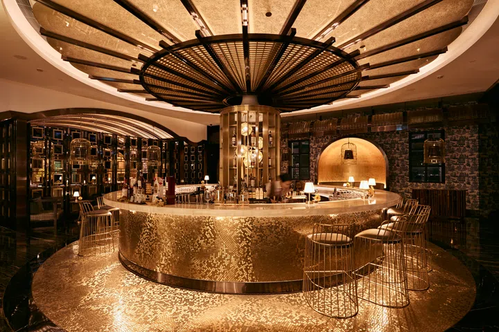 Mesa by José Avillez 餐厅内部，金色圆形吧台与几何吊灯相互辉映，展现澳门上葡京的中西合璧风格与优雅氛围。澳门3天2夜旅游攻略。