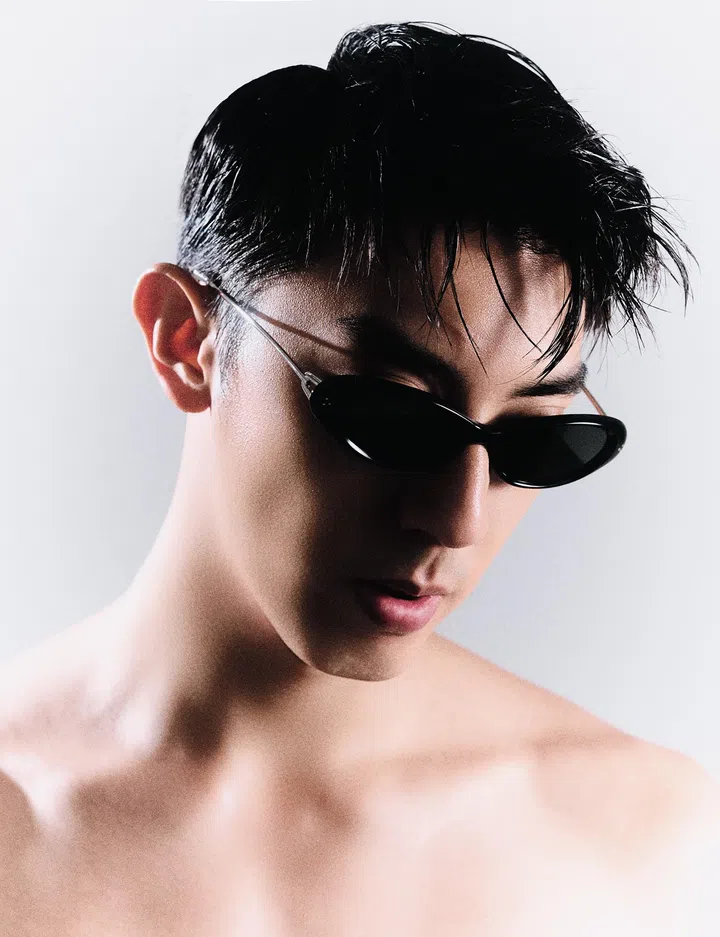仲伟杰近距离人像，佩戴黑色墨镜，湿发造型，裸肩入镜，在简洁背景下展现冷峻与时尚感的男性形象。