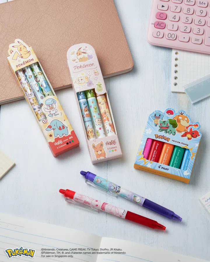 $20以下也能送出好礼：同事交换圣诞礼物精选。图中展示 Pokémon x Pilot Pen FriXion 可擦笔与印章系列，多款角色设计如皮卡丘、伊布、小火龙等，搭配笔记本、计算机与文具拍摄，呈现可爱又实用的文具礼物氛围。