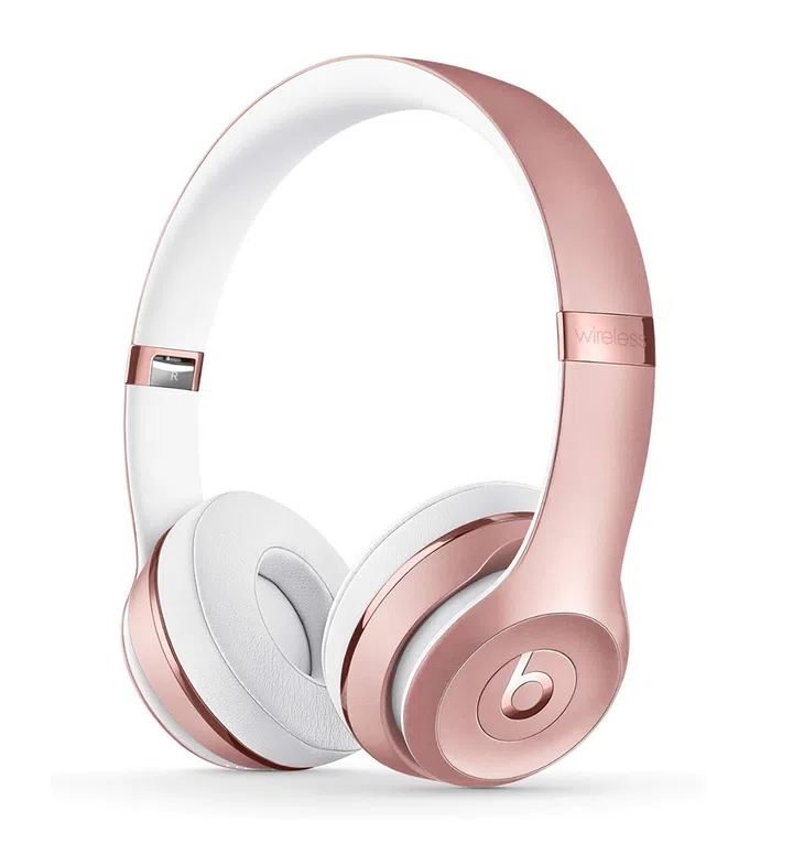 玫瑰金配色的Beats Solo 3头戴式耳机，白色耳垫搭配金属质感耳机架，侧面印有标志性的 “b” logo。