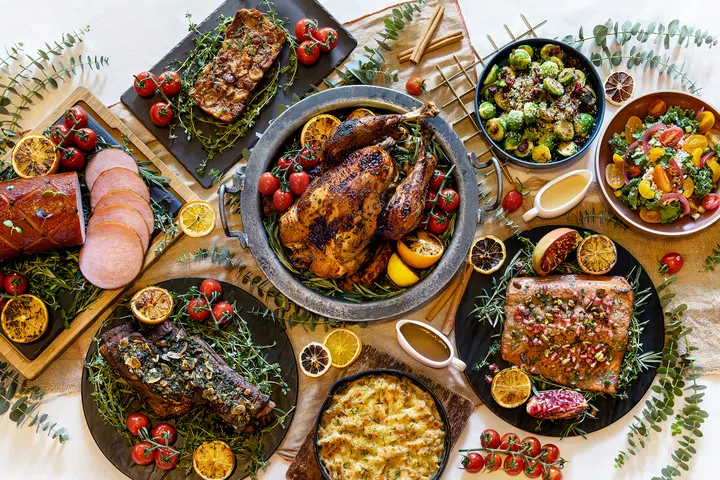 The Marmalade Pantry 的节庆外带大餐摆满整桌，包括烤火鸡、波本杏干烤火腿、慢煮牛小排、烤三文鱼、布鲁塞尔芽菜、沙拉和芝士通心粉等季节性料理，呈现丰盛的节日盛宴。2025圣诞外带套餐推荐：在家享用超值又美味的圣诞大餐