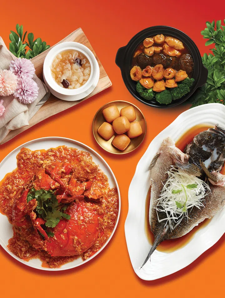 JUMBO Seafood母亲节套餐料理图：画面摆满适合家庭聚餐的经典中式海鲜料理，包括招牌辣椒螃蟹、清蒸鱼、鲍鱼海参煲、甜汤与金黄小馒头等，整体色彩鲜艳丰富，充满热腾腾的团圆聚餐氛围。2026母亲节餐厅精选指南