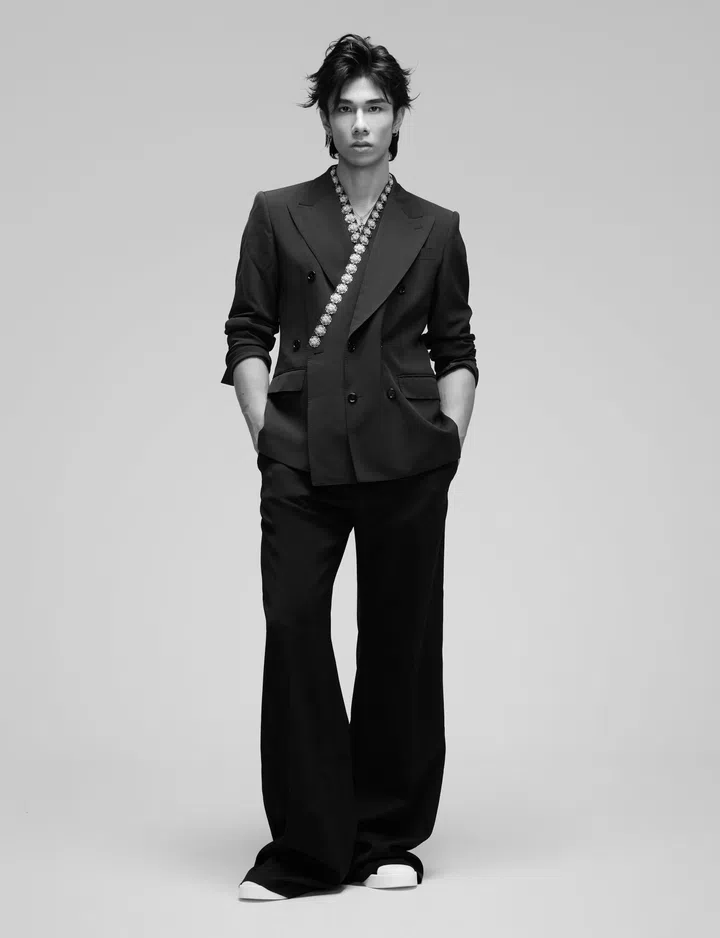 Why Lucas身穿Dolce&Gabbana双排扣外套与阔腿长裤，颈间点缀项链，脚踩简约鞋子。他双手插袋站立，气质冷峻而时尚。