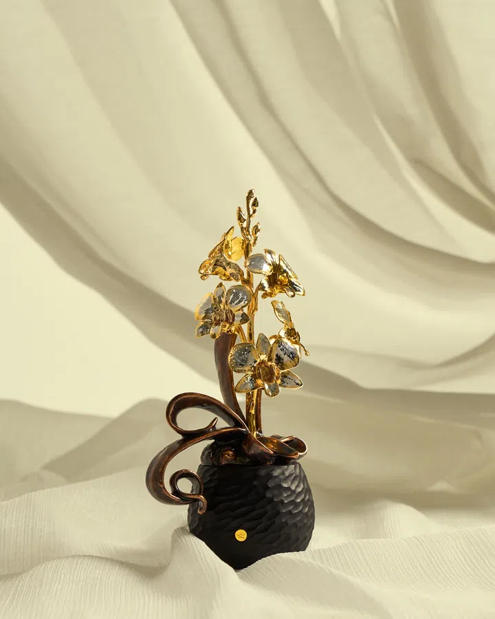 RISIS 迷你石斛兰艺术盆景 $768 
以天然Dendrobium兰花封存于24K瑞士金与钯金之中，搭配黑色锤纹花器与金属枝蔓呈现