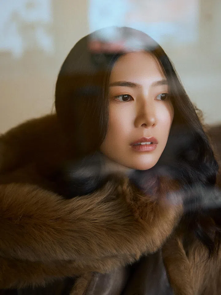 Ferlyn身穿棕色毛绒大衣近距离出镜，长发披肩，神情若有所思，画面带有柔和朦胧感。