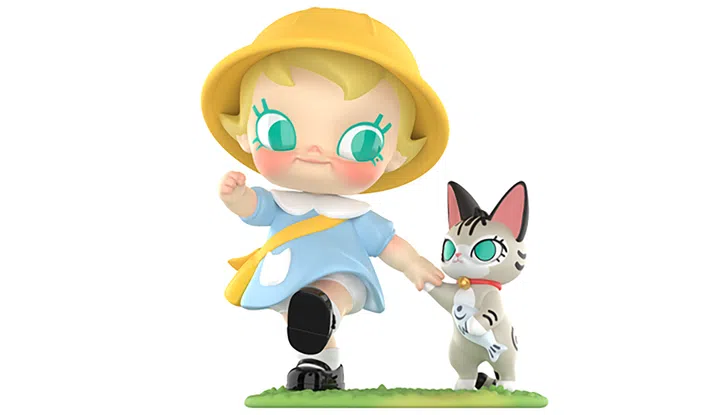 一款 POP MART Baby Molly 系列玩偶模型。角色是金发碧眼的 Baby Molly，头戴黄色圆顶小帽，脸颊泛着红晕，穿着蓝色连衣裙和黑色小皮鞋，肩上斜挎黄色书包。她正抬起一只脚，摆出前进的姿势，手里牵着一只小猫。小猫拥有绿色大眼睛、黑白相间的花纹，嘴里叼着一条小鱼，脖子上戴着红色项圈。整体场景充满童真和冒险感，表现出 Baby Molly 与宠物一起出发的俏皮氛围。POP MART Baby Molly喵趣横生系列中的“一起去上幼稚园”。