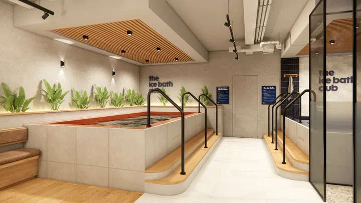 $20以下也能送出好礼：同事交换圣诞礼物精选。图中为 The Ice Bath Club Duxton 新店内部空间，包含大型冰浴池、木质阶梯、绿植点缀与简洁灯光设计，呈现主打身心放松与恢复的现代疗愈环境，适合搭配介绍礼券类节日礼物。