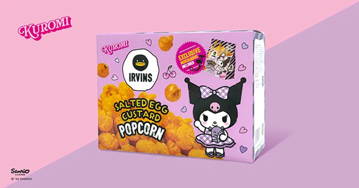 IRVINS × Kuromi联名咸蛋奶黄爆米花礼盒包装展示。盒子以粉紫色为主色调，印有Sanrio人气角色Kuromi身穿紫色格纹蝴蝶结裙子的可爱形象，搭配IRVINS经典黑鸭标志。包装上标注“Salted Egg Custard Popcorn”，并附有独家Kuromi主题包装袋图案，整体设计少女感十足，结合IRVINS的招牌咸蛋风味与Sanrio卡通IP。