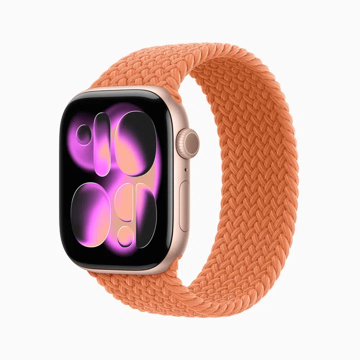 Apple Watch Series 11 智能手表产品照，采用玫瑰金色铝金属表壳搭配橘粉色编织表带，整体设计简约时尚又带有柔和质感。手表屏幕展示紫粉色渐层图案，突显 Apple 一贯的现代科技感与精致设计风格。除了具备健康追踪、睡眠监测与日常通知功能外，整体外型也非常适合作为日常穿搭配件，是兼具实用性与时尚感的母亲节科技礼物推荐。母亲节礼物推荐2026：从实用家居到时尚科技，这些礼物妈妈真的超爱！