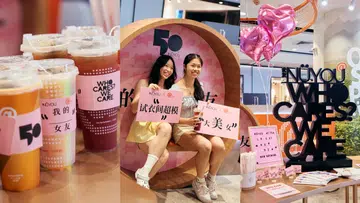《女友》50周年与At Tea联名活动现场，画面由三部分组成：左侧为多杯贴有《女友》50周年联名杯套的茶饮；中间两位参与者坐在粉色主题拍照装置前，手持趣味标语牌拍照留念；右侧展示“NÜYOU WHO CARES? WE CARE!”主题装置、粉色爱心气球及联名活动展示区，呈现联名活动温暖、轻松且充满互动感的氛围。