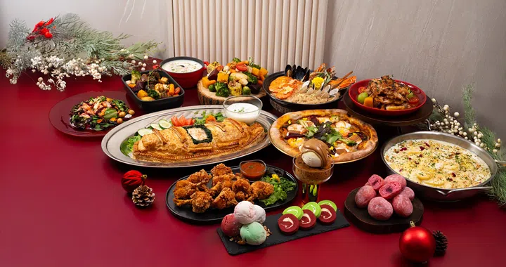 一整桌 Swensen’s Unlimited 圣诞自助餐料理摆在红色桌面上，包括烤火鸡、冷水浸煮三文鱼、圣诞烤鱼派、蜜汁烤鸡火腿、冬季牛肉砂锅、圣诞薄饼披萨、Boxing Chicken、节日海鲜烩饭、波士顿海鲜巧达汤、烤蔬菜、马卡龙、太妃布丁、覆盆子甜甜圈、瑞士卷，以及多种节日甜点与冰淇淋，整体呈现节庆氛围与丰盛摆盘。圣诞大餐吃什么？新加坡9家必订自助餐全攻略