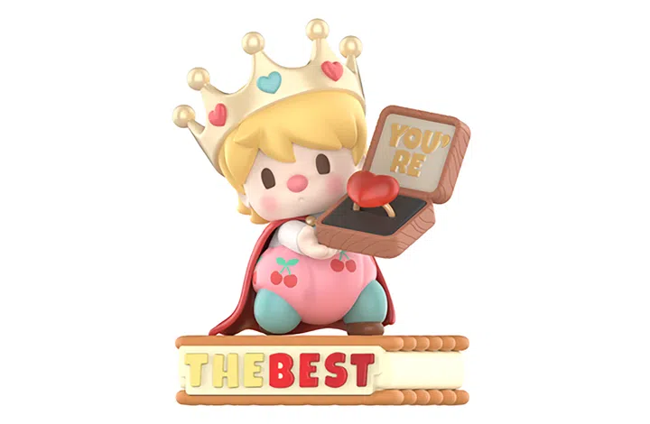 一款 POP MART Sweet Bean（小甜豆） 系列玩偶模型。角色是一位婴儿形象，圆脸红润，头戴金色皇冠，上面点缀爱心装饰。Sweet Bean 身披红色斗篷，穿着印有樱桃图案的粉色裤子，手里举着一个打开的戒指盒，盒内放着一枚红色爱心戒指，盒盖内写有金色大字 “YOU’RE”。角色站在一个饼干造型的底座上，上面拼出 “THE BEST” 字样。整体造型呆萌可爱，融合了童趣、甜蜜与浪漫的氛围。POP MART Sweet Bean小甜豆有关爱的语言系列中的“你是最好的”。