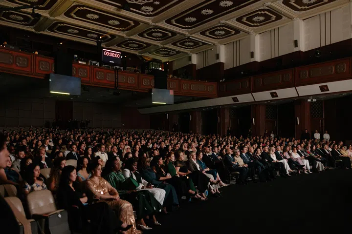 Cartier Women’s Initiative 20周年颁奖礼现场座无虚席，来自世界各地的创业者、企业领袖、投资人、媒体及合作伙伴齐聚泰国曼谷朱拉隆功大学大礼堂，共同参与庆典。观众身穿正式礼服与西装，聚精会神地望向舞台，宽敞的礼堂拥有高挑天花板及深色木质装潢，展现庄重而国际化的典礼氛围。