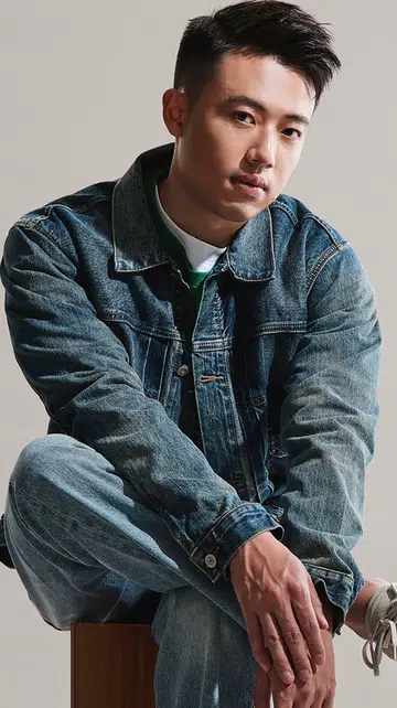 MEN WE LOVE: TYSON LIM HomeEZ创办人。画面中，Tyson Lim身穿牛仔外套与牛仔裤，坐在木质座椅上，神情沉稳自信。他是 HomeEZ 的创办人，致力于简化新加坡的装修流程，让屋主能以更透明、直接的方式对接分包商，提升效率并降低预算。