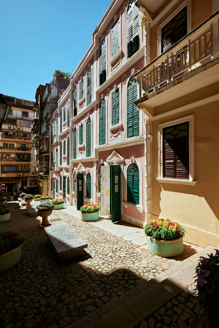 澳门恋爱巷的粉色外墙与绿色窗户交织成浪漫画面，是拍摄大三巴牌坊的隐藏取景点。澳门3天2夜旅游攻略。