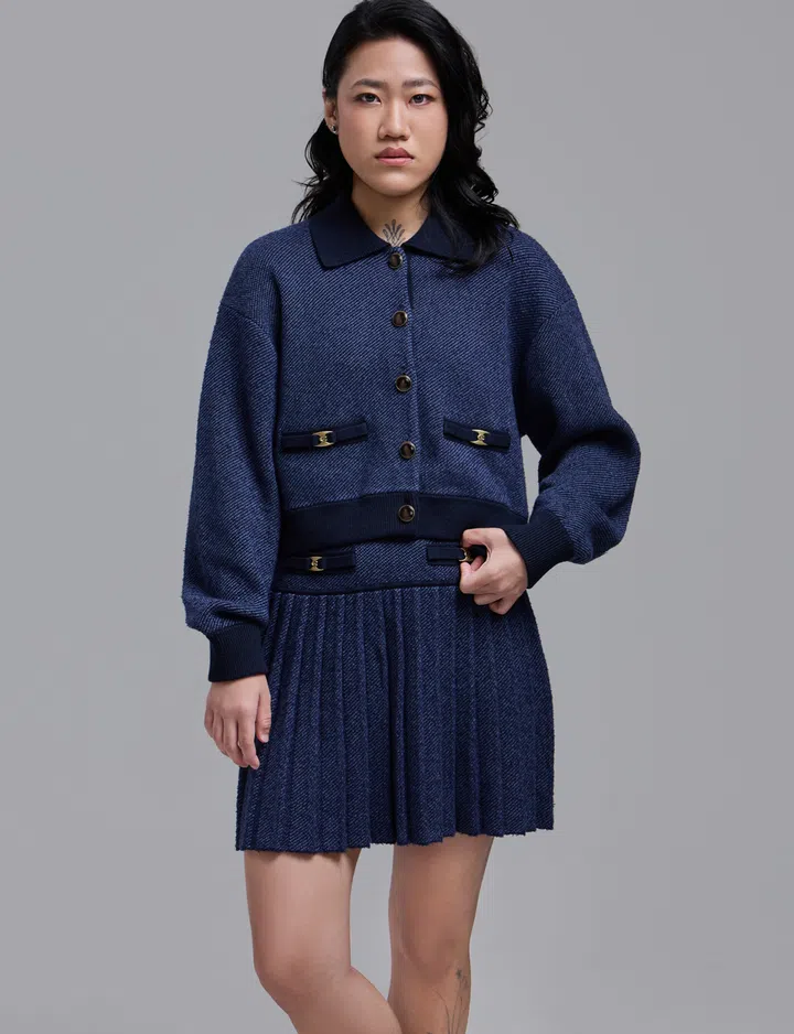 smolchet创办人Marilyn林欣宁身穿深蓝色套装，正面站立直视镜头。她是29岁的时装设计师，也是微钩编创作者，将手作兴趣发展为事业。