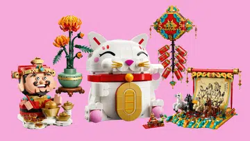 粉色背景上展示多款LEGO农历新年主题积木摆设，包括一只白色招财猫造型积木，带有金色钱币与红色项圈；一尊财神爷人偶，周围摆放金元宝与金币；一盆橙黄色菊花植物造型盆栽；一组可悬挂展示的红色爆竹与传统中式装饰结构；以及一幅以骏马为主题的动态画轴积木场景，呈现多匹马奔跑的立体画面。整体色彩以红、金、白与绿色为主，营造出浓厚的新春节庆氛围，适合作为农历新年居家装饰与收藏摆设。