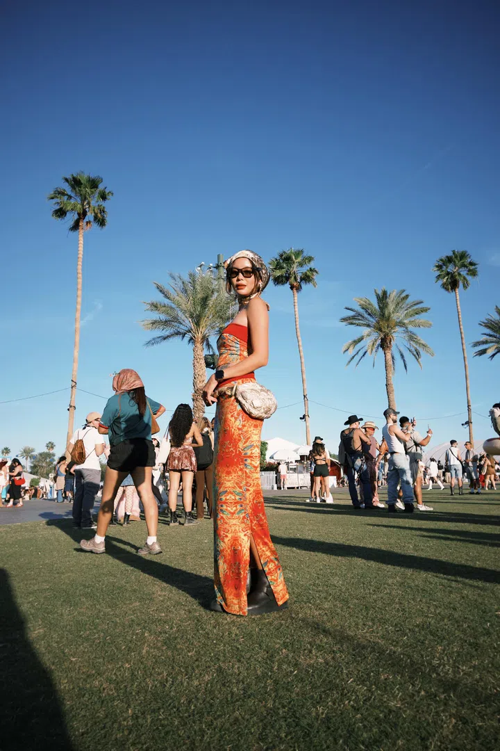 符芳榕身穿红色印花长裙在户外音乐节留影，背景是蓝天与棕榈树，气场全开。符芳榕，命运使者，离开演艺圈，专访