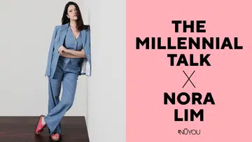 《女友》The Millennial Talk 专访 Nora Lim 的专题封面。画面左侧为 Nora Lim 身穿浅蓝色西装套装，包含西装外套、V领马甲及宽松长裤，身体轻倚白色墙面，双手自然交叠，神情自信从容，脚穿亮粉色凉鞋，为整体造型增添活力与时尚感。背景采用浅灰色墙面与深色木地板，营造简洁明亮的摄影棚氛围。右侧为粉红色版面设计，印有黑色大字“The Millennial Talk × Nora Lim”及《女友》NÜYOU 标志，整体呈现现代时尚杂志人物专访风格，并呼应创业、自我照顾、舒适生活与现代女性平衡事业与家庭的主题。