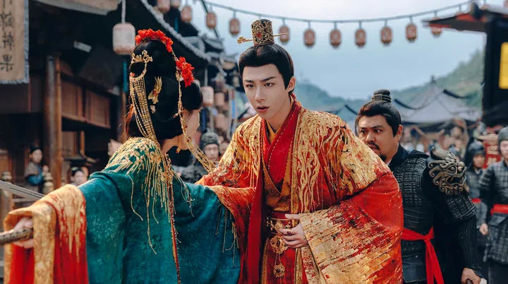 身着红金锦袍的男子在古镇街道上与身穿青绿色华服的女子对话，背景为古风建筑与士兵，呈现出《书卷一梦》中浓厚的古装氛围与情感张力。书卷一梦剧照
