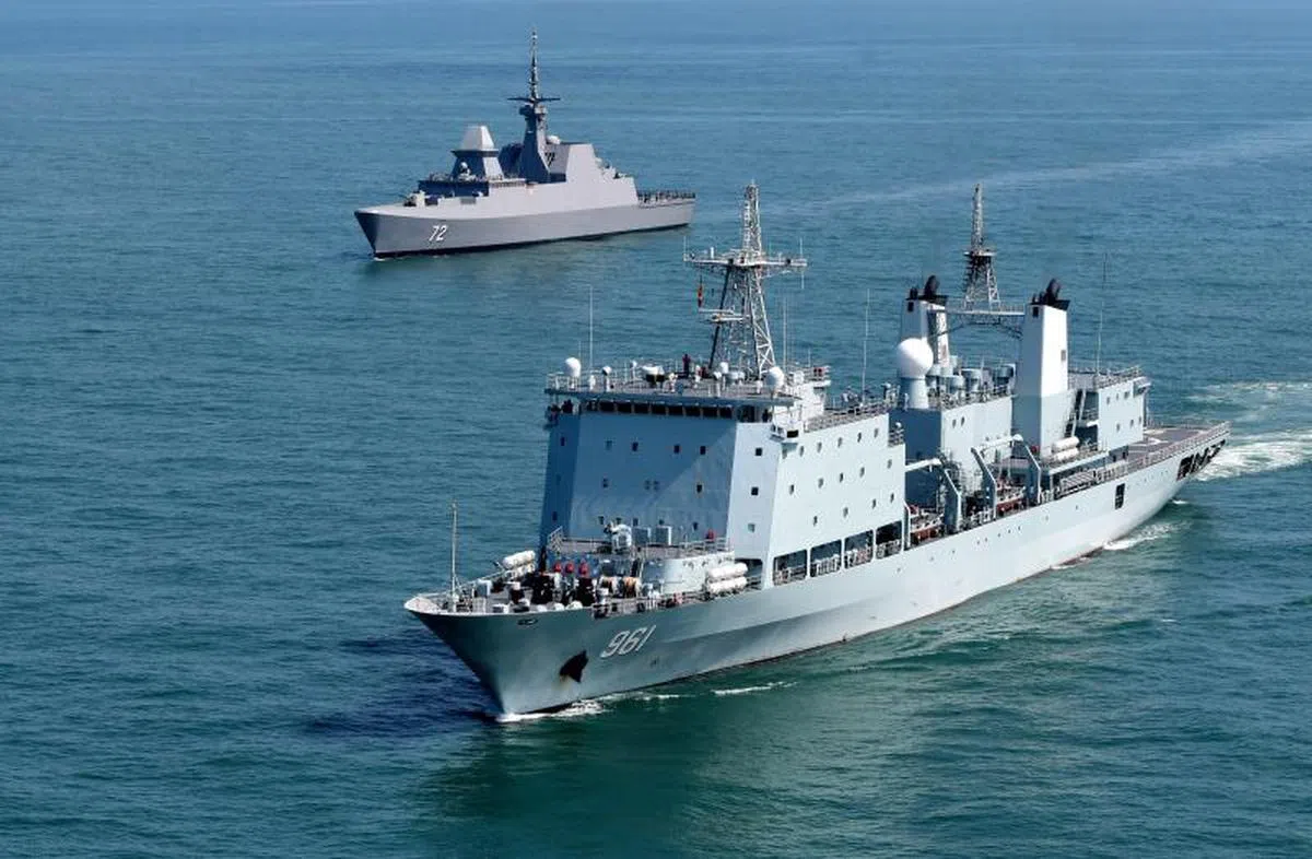  中国-亚细安“海上联演-2018”实兵演练10月25日至26日在湛江以东海空域演习区展开。图为中国海军综合补给舰军山湖舰（右）与新加坡海军“忠诚”号护卫舰（左）补给机动占位演练。（中新社） 