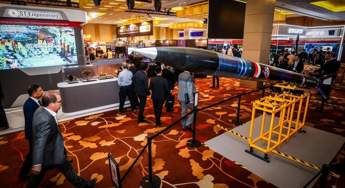 多家航天相关企业在2026年的首届航天峰会设摊，展示产品与服务。图左为新科工程展示地球观测卫星模型；右边是航天公司Equatorial Space公司开发，用于推进系统测试的火箭模型。