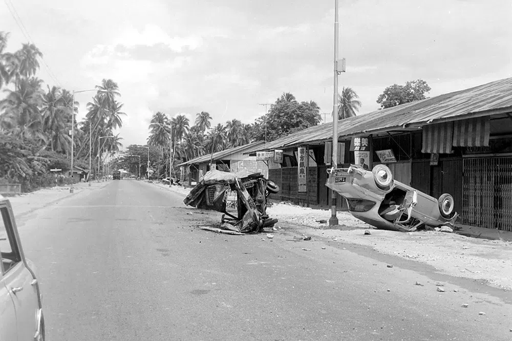 1964年种族暴乱，巴耶利峇一带一辆汽车被暴民翻转过来后，弃置路旁。