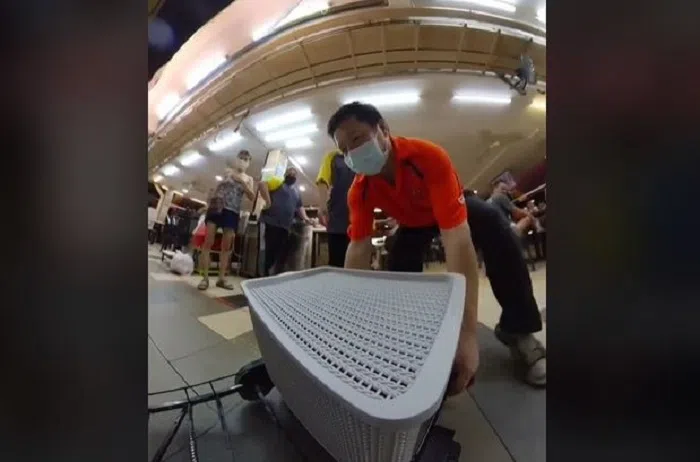 摊位助手出手挪车，才能让它继续行驶。（视频截图）