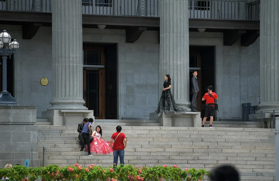 新加坡摄影师为两组新人在户外拍婚纱照。（海峡时报）