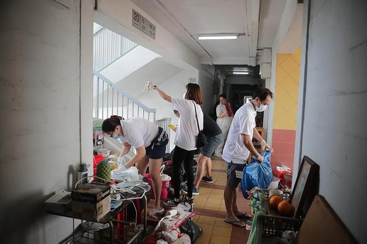  义工们在走廊上为囤积物分门别类。（海峡时报） 