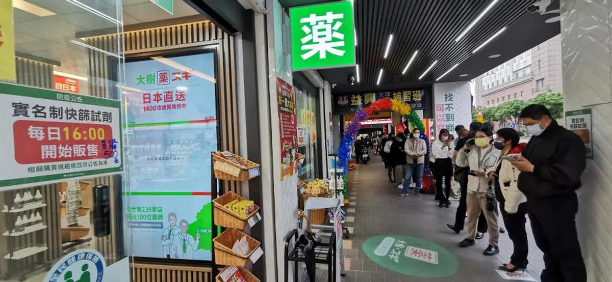 台北市政府捷运站附近的这家药房引来70多人排队，等着下午4时开放抢购500元（新台币，约23新元）的五剂装抗原快筛剂。（联合早报）