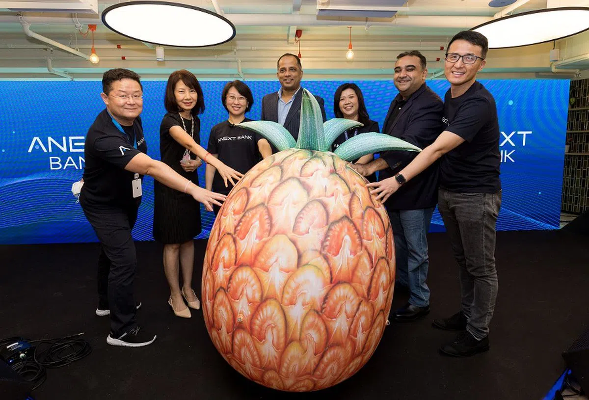 蚂蚁集团在新加坡的数码银行“星熠数字银行”6月6日开业，以巨大黄梨装饰表达“旺来”好运寓意。图左起：蚂蚁集团东南亚总经理郏航、星熠数字银行独立董事朱瑞毓、蚂蚁集团国际事业群总裁赵颖、金管局首席金融科技官莫汉蒂、星熠数字银行首席执行官卓淑美、Proxtera首席执行官巴塔查里亚（Saurav Bhattacharyya），以及蚂蚁集团国际事业群首席财务官周毅。（星熠数字银行提供）
