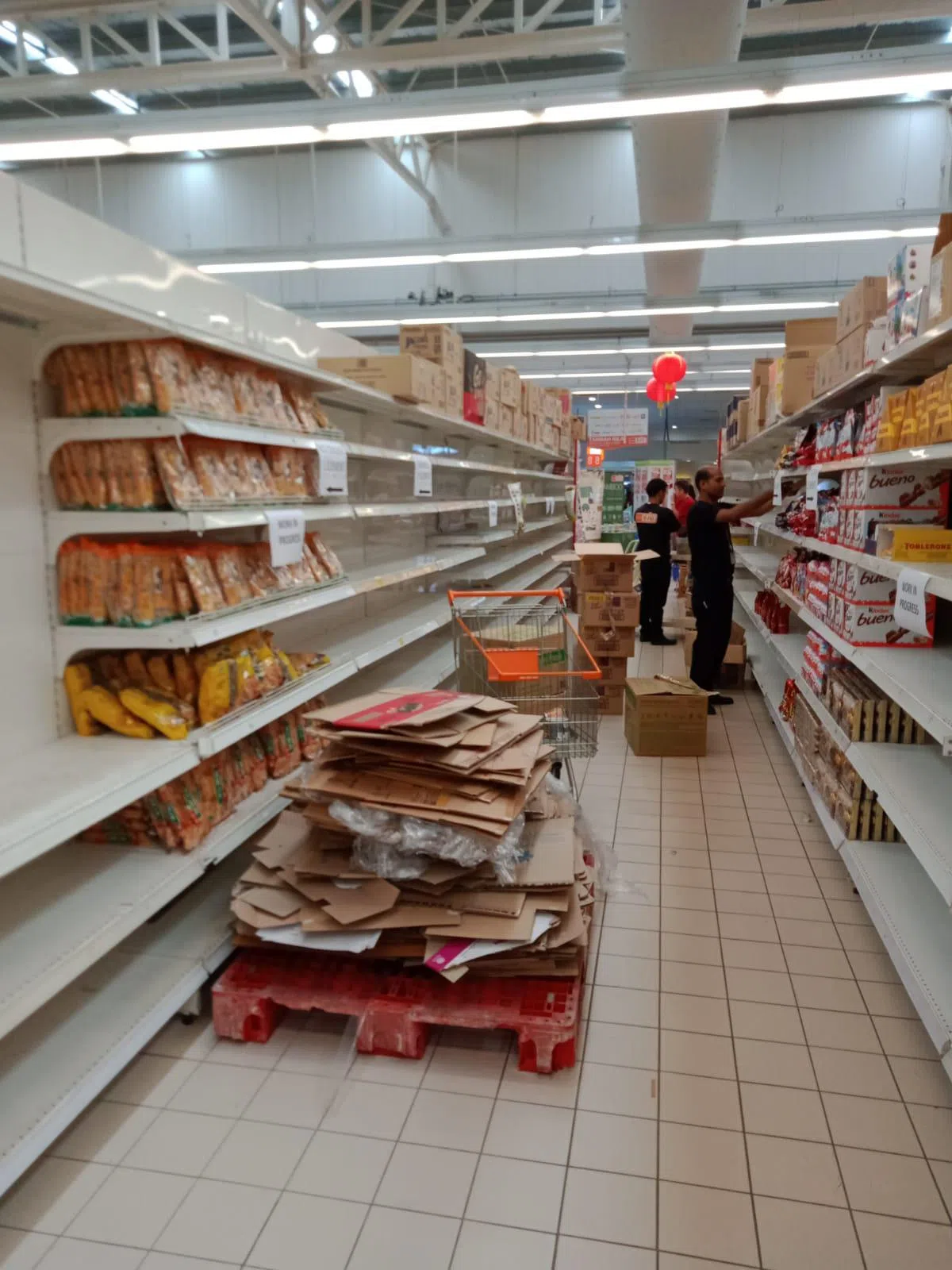  工作人员忙着补充货架上的饼干。（李国豪摄） 