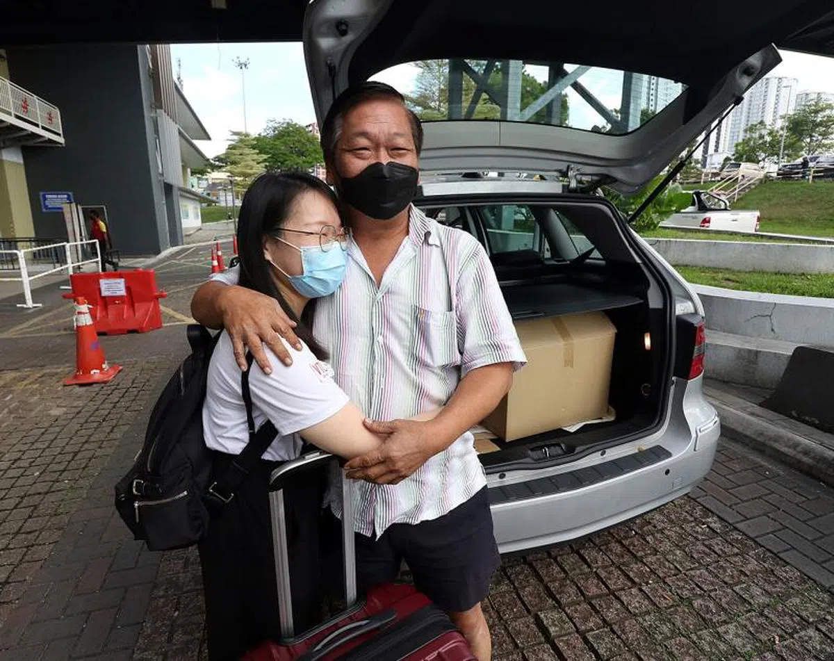 一名从新加坡返回新山的乘客张月馨（左）见到许久未见的父亲，激动地上前拥抱。（星洲日报）