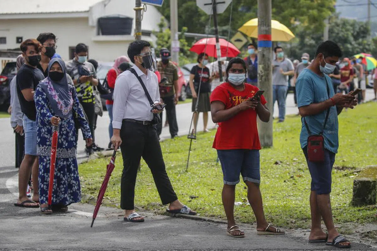  马国雪兰莪州确诊病例居高不下，连日成为全国病例人数最高的州属。当地社区检测中心外排起长长人龙，民众进行免费冠病检测。（欧新社） 