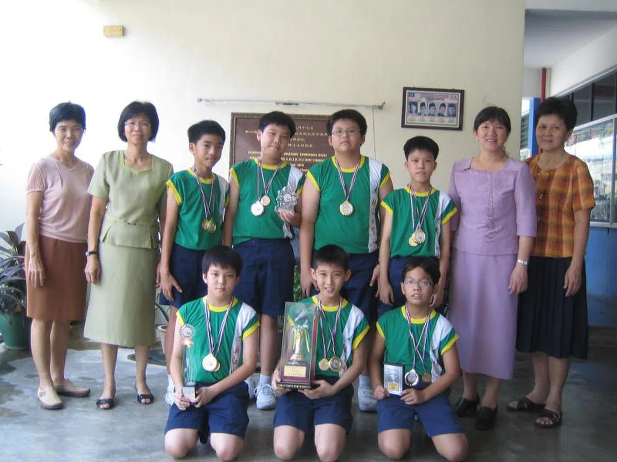 骆建佑（前排中）与同学们拿下2009年槟城州学联羽球赛总冠军。（陈华华校长提供）