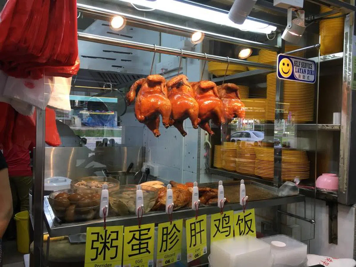 鸡饭摊总挂着一排排的烧鸡或白鸡。（晚报新闻） 