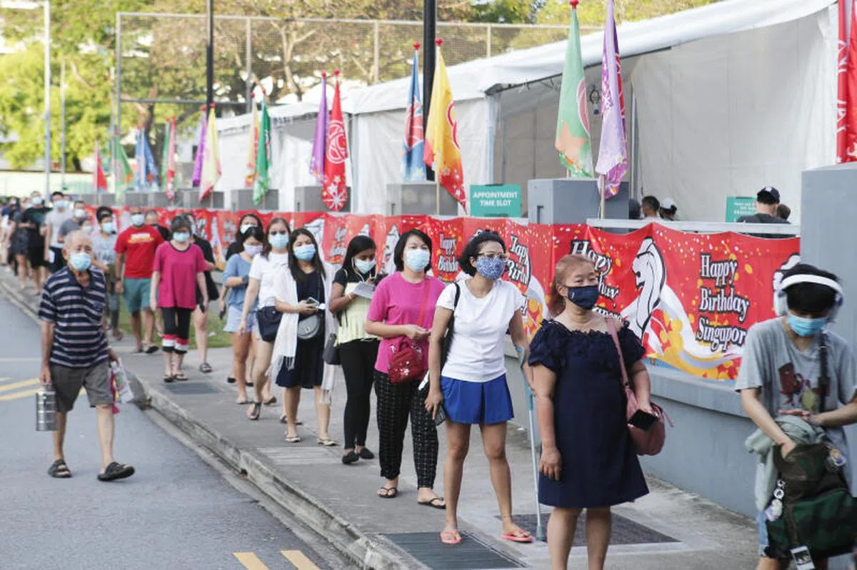   德义民众俱乐部外排队接种的民众。（联合早报） 