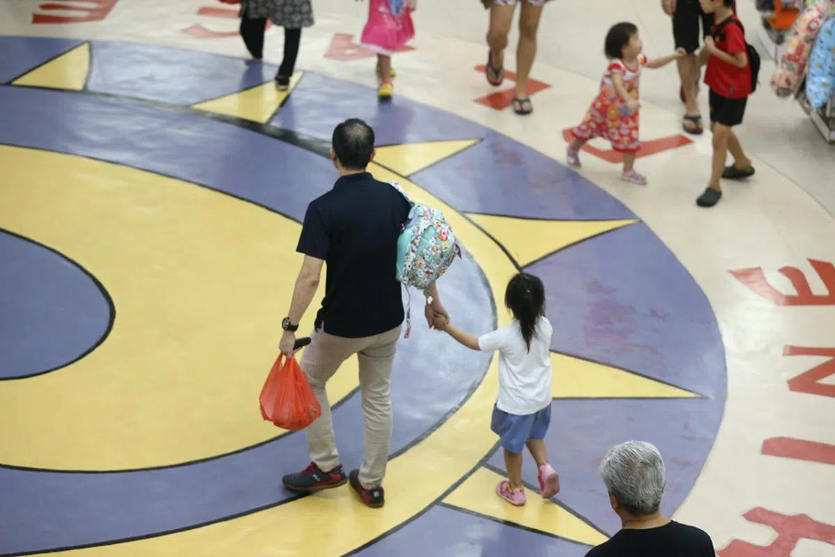 不少家长下班后，还得到托儿所接孩子回家。（海峡时报）