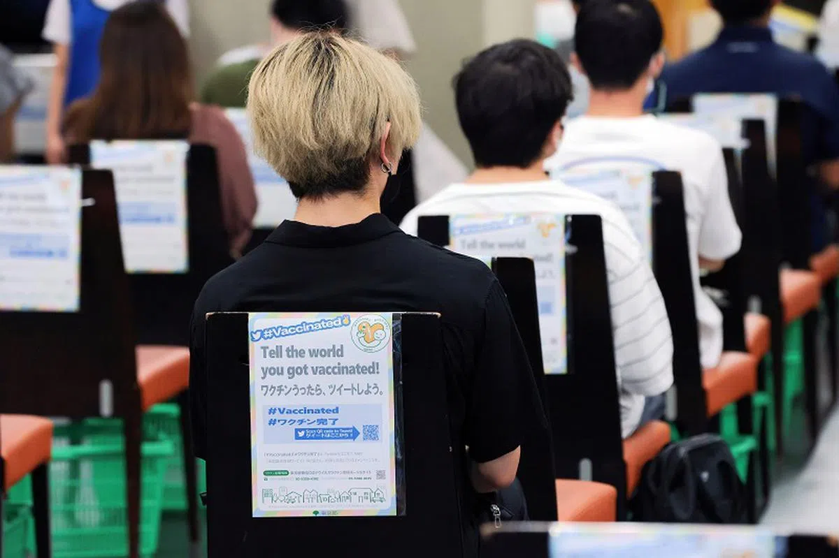  日本一所大学的冠病疫苗接种处的一直背后写着：请告诉全世界你打了疫苗！（彭博社） 