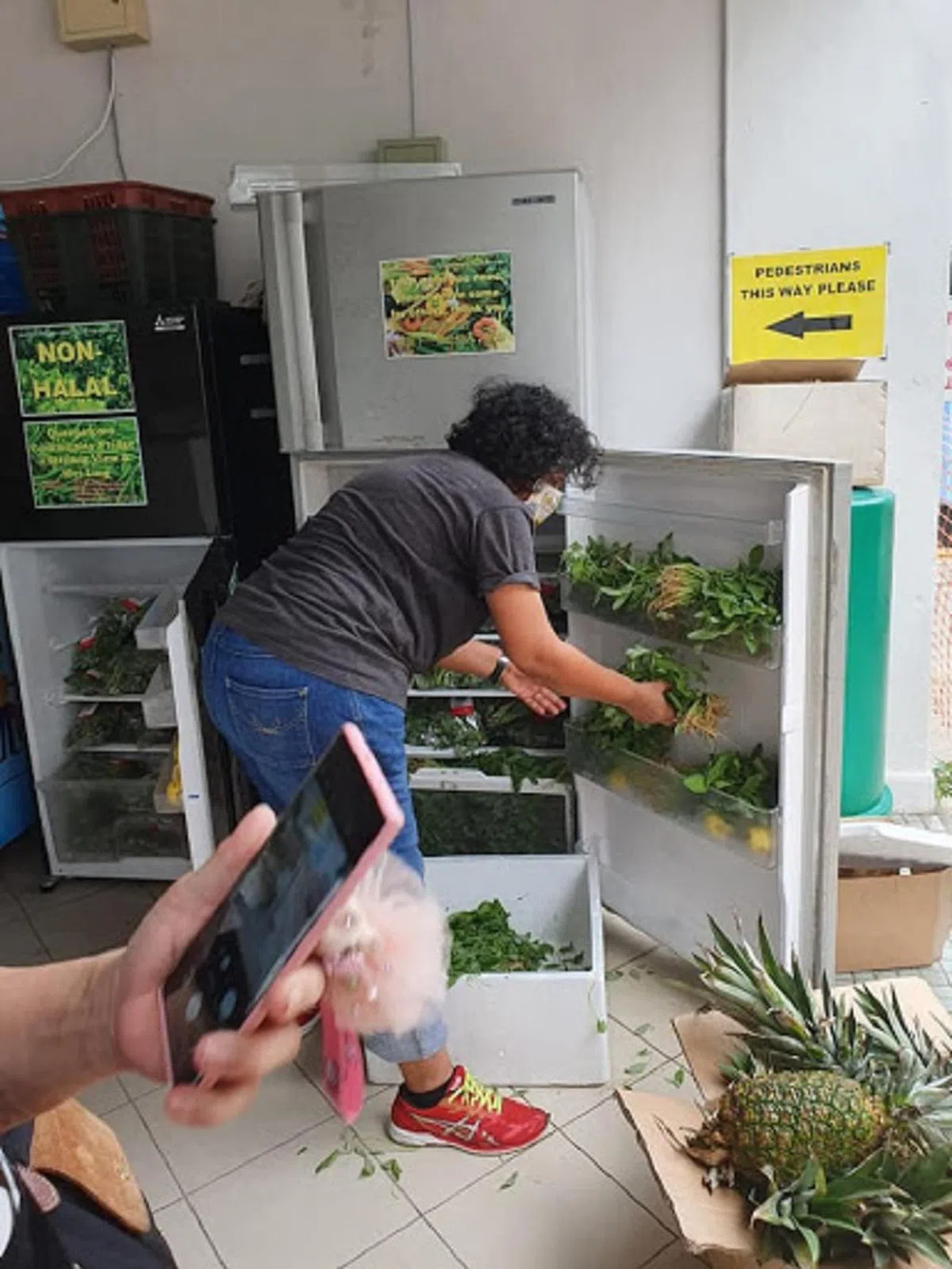  志愿者在把收集到的食物放进社区冰箱。（填补社区冰箱志愿团体面薄） 