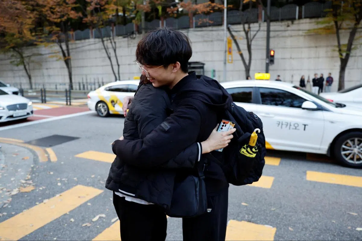 一名母亲在孩子奔赴考场前给予他拥抱。（路透社）