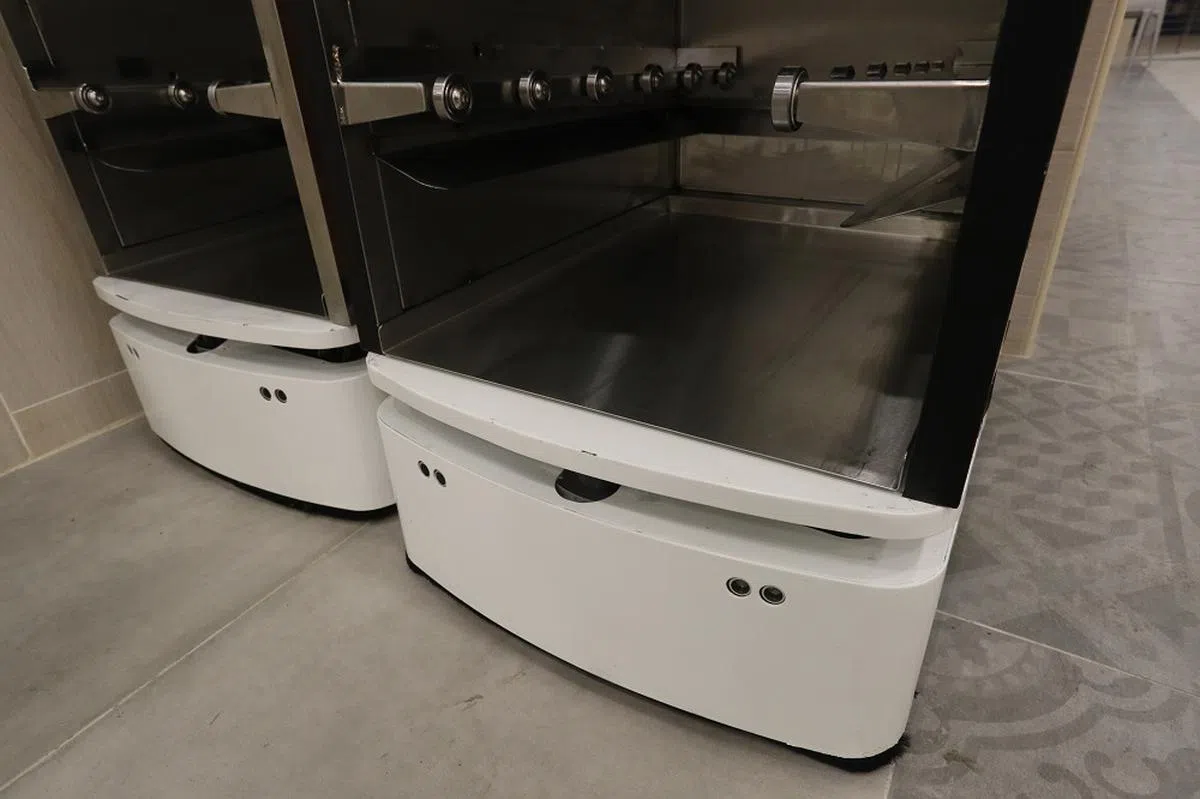 机器人的“脚下”有感应器，前方出现食客或障碍物时，就会立刻停下。（联合早报）