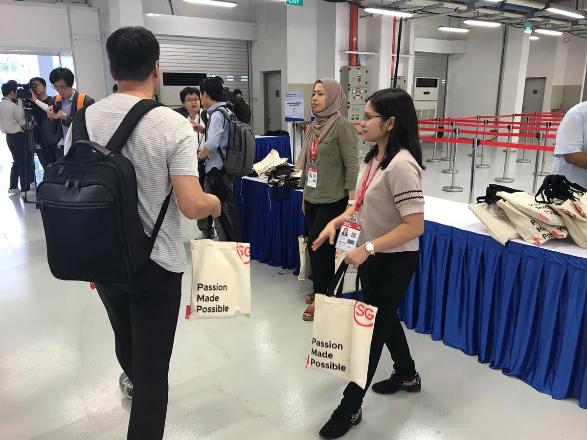  领取证件后，就有工作人员主动派发媒体包。（卢凌之摄） 