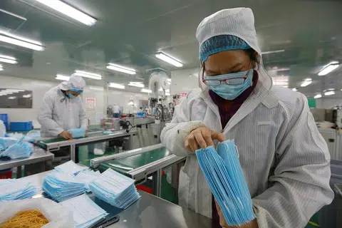 江西省吉安市峡江县医疗用品企业生产车间，工人正在加速生产一次性医用口罩。（新华社）