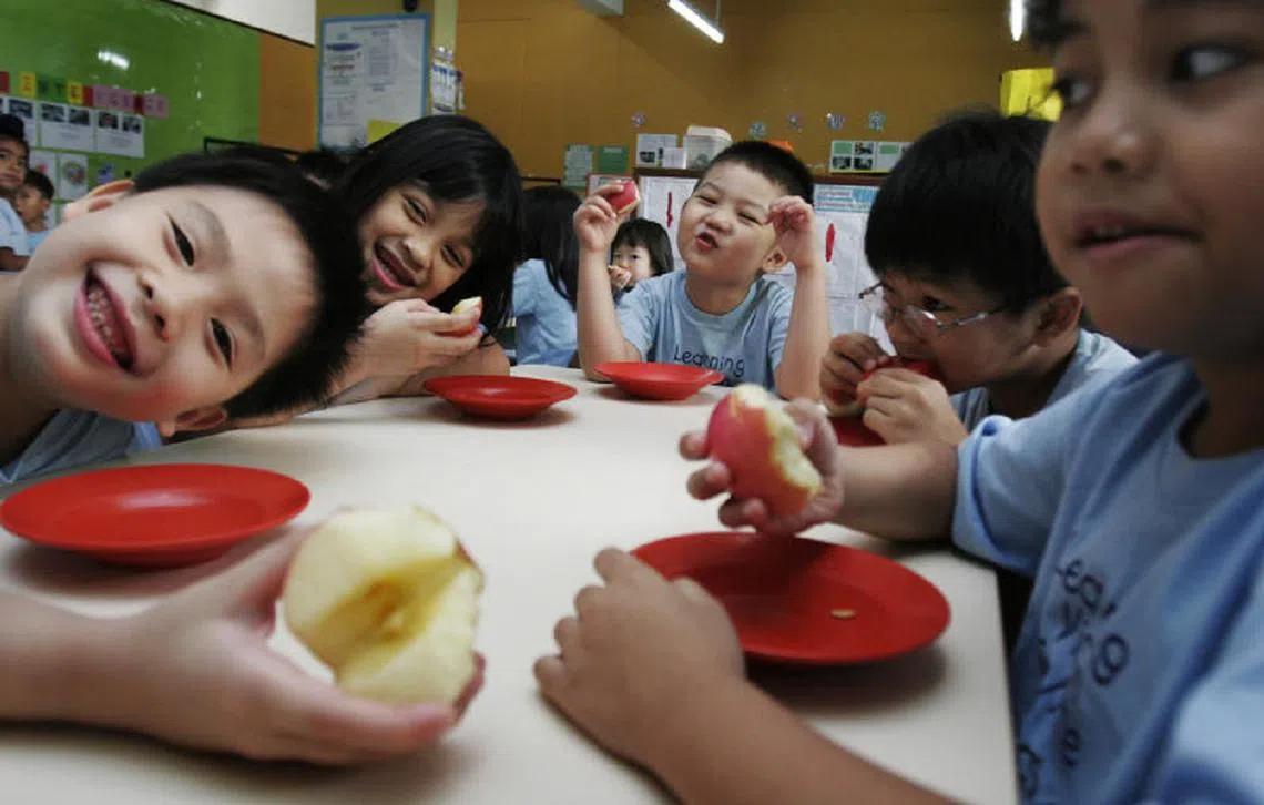 托儿中心的孩子们吃完午餐后吃水果，营养均衡。（海峡时报）