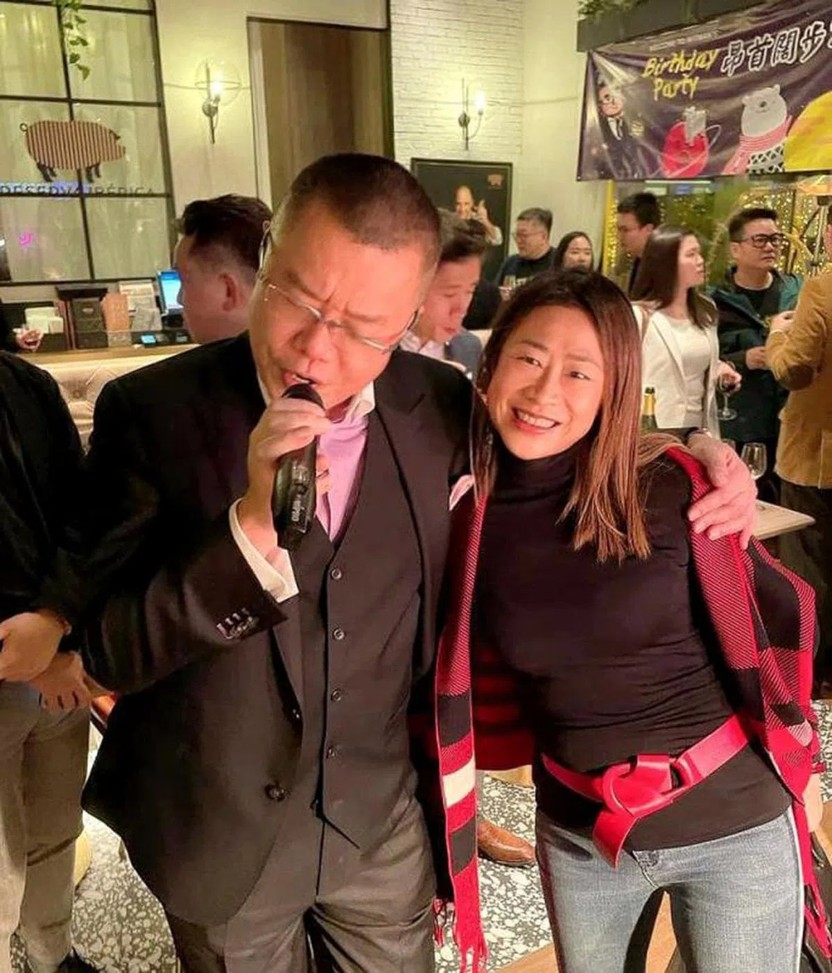 网络流传的照片显示，当日寿星洪为民（左）和选举委员会选委曾凤珠（右）没有戴着口罩唱歌，其余在场人士也大多没有佩戴口罩。（互联网）