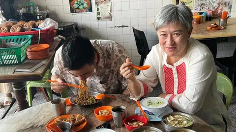 黄英贤（右）和弟弟黄建平（左）一起品尝亚庇当地美食。（澳大利亚广播公司）