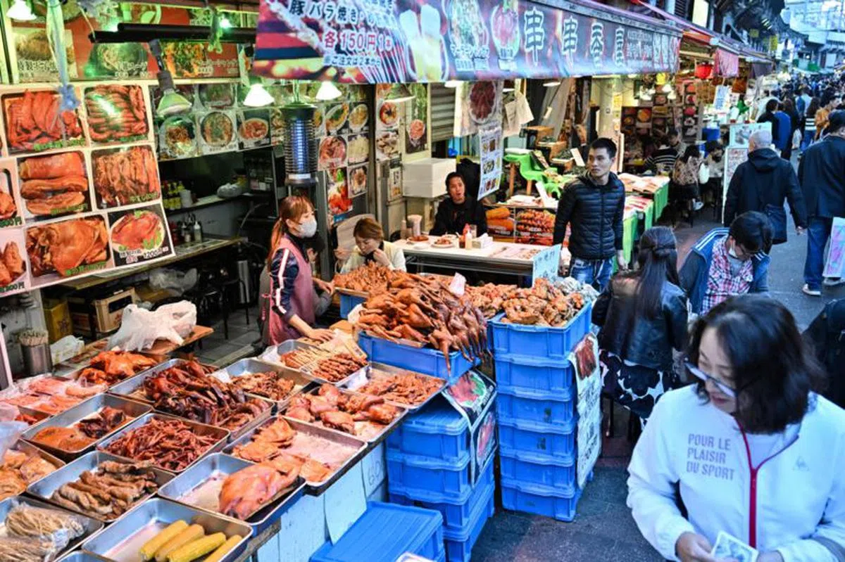 阿美横丁商店街也有卖串儿，猪脚、鸭脖子等中国食品。（日本经济新闻）